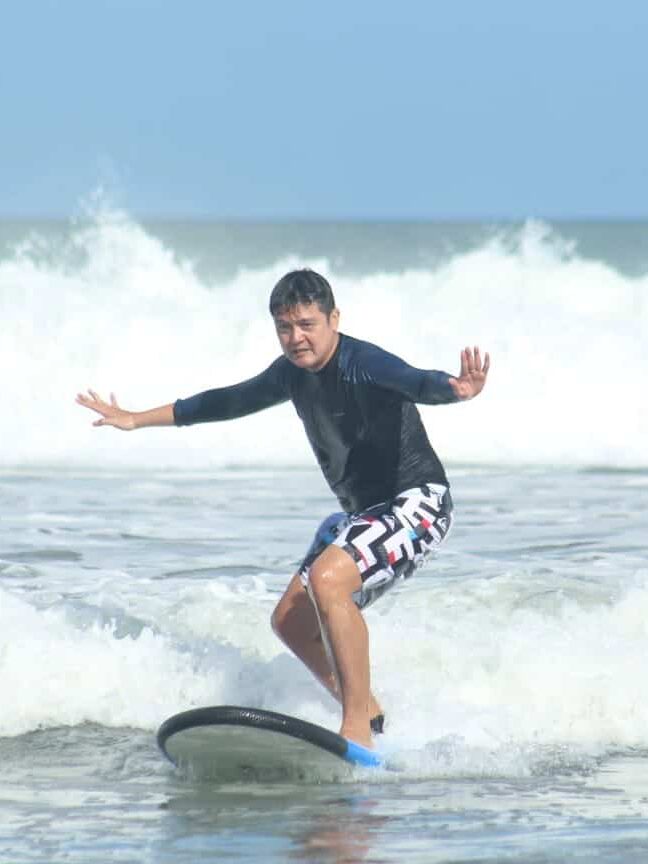 Edwin trying his best not to fall off the surf board in Kuta Bali